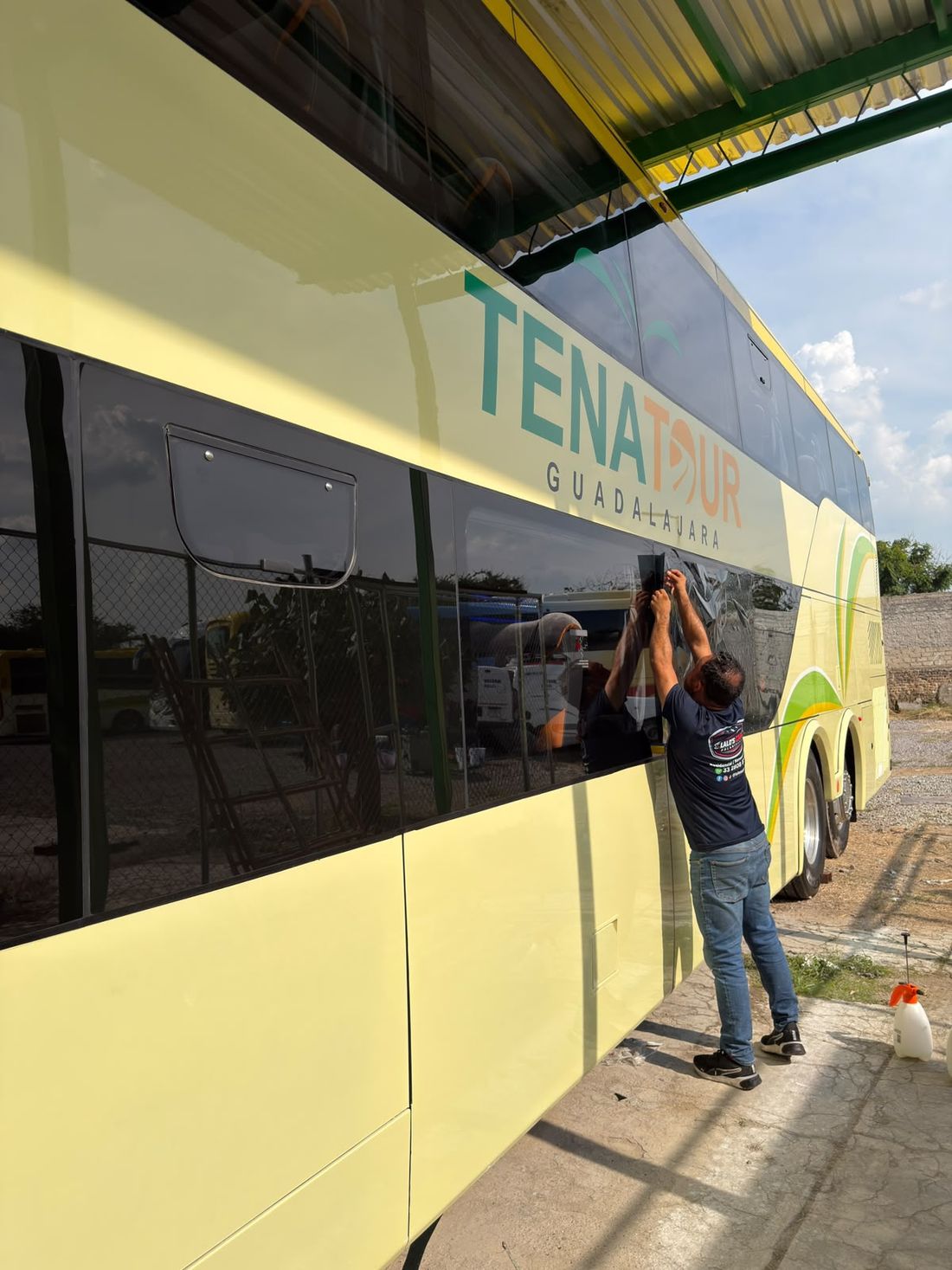 Instalador de Lalo's Cars polarizando las ventanas de un autobús de turismo de dos pisos
