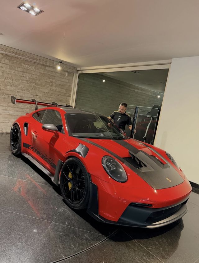 Instalador de Lalo's Cars trabajando en un Porsche 911 GT3 RS rojo en la cochera del cliente